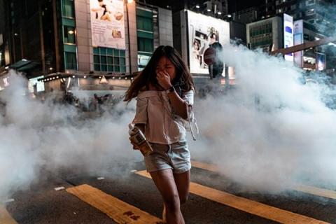 一名女生在催泪弹浓烟中奔逃。示意图（Anthony Kwan/Getty Images）