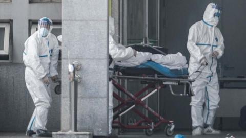 图为武汉金银潭医院，医护人员身穿全套防护服接收患者。(STR/AFP via Getty Images)