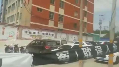 陕西一名小学生复课死于学校，家长拉横幅讨公道。（视频截图）