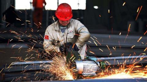 拍摄于2016年4月30日对照片，展示了中国山东省日照市一家结构钢厂的一名工人正在对一件产品进行抛光作业。(STR/AFP via Getty Images)