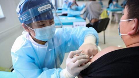 1月8日，北京医护人员给一名男子接种。（STR/CNS/AFP via Getty Images）