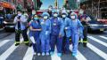 图为纽约医护人员在街上与消防人员合影。（Cindy Ord/Getty Images)