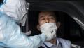 图为日本一位医疗人员在采集病毒样本。（Tomohiro Ohsumi/Getty Images）