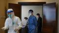 2020年10月22日，中国北京一家酒店，一名卫生工作者身穿防护服为一名工作人员核酸检测。(Kevin Frayer/Getty Images)