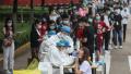 图为2020年5月15日,湖北省武汉市戴着口罩的居民排队等待中共病毒检测。 (Getty Images)