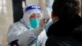 2021年1月14日，在中国黑龙江省哈尔滨市的一栋办公楼中，一名医务人员正在给一名男子取样，以进行中共病毒(Covid-19)检测。(STR/AFP via Getty Images)