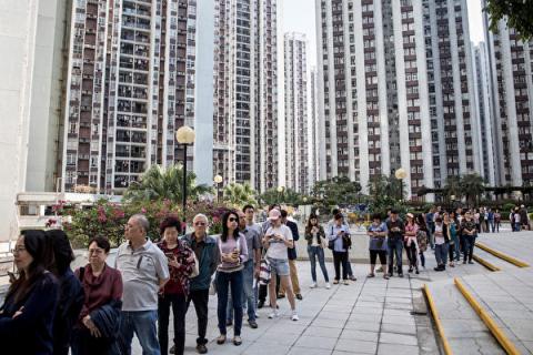 香港民众11月24日当天井然有序地排队投票，本届区议会选举投票率达71.2%，创下历史新高。(Chris McGrath/Getty Images)