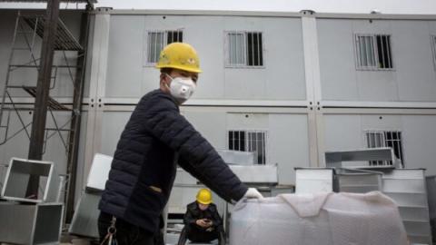 图为火神山医院外景，工人在建造过程中。（Getty Images）