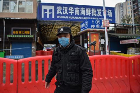 1月25日一名公安站在华南市场外。(Hector RETAMAL/AFP)