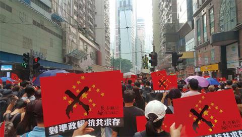 2019年9月29日，“全球连线-共抗极权”游行活动。香港民众手举反中共赤纳粹的海报。（林志龙／大纪元）
