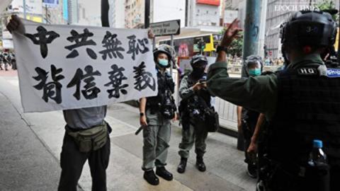 图为2020年7月1日民众手持“中共无耻背信弃义”标语。(宋碧龙/大纪元)