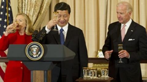 图为2012年2月14日，时任中共接班人的习近平（中）在华盛顿美国国务院的午餐会上，与时任副总统拜登（右）和时任国务卿希拉里•克林顿（左）敬酒。（Jim Watson/AFP via Getty Images）
