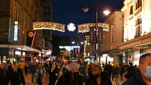 2020年12月19日，行人和购物者戴着口罩走过皮卡迪利（Piccadilly）的商店。(OLI SCARFF/AFP via Getty Images)