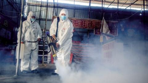 图为黑龙江绥芬河防疫人员在消毒场所。（STR/AFP via Getty Images）