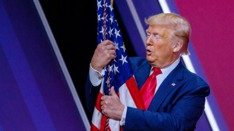 2月29日，川普总统在马里兰州国家港口（National Resort）举行的年度保守政治行动会议（CPAC）上拥抱美利坚合众国的国旗。（Tasos Katopodis / Getty Images）